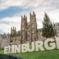 Travel advisor assisting client with personalized trip planning in Edinburgh featuring maps and travel guides