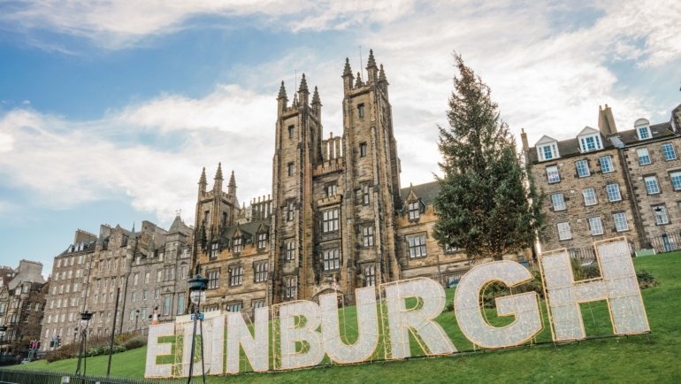 Travel advisor assisting client with personalized trip planning in Edinburgh featuring maps and travel guides