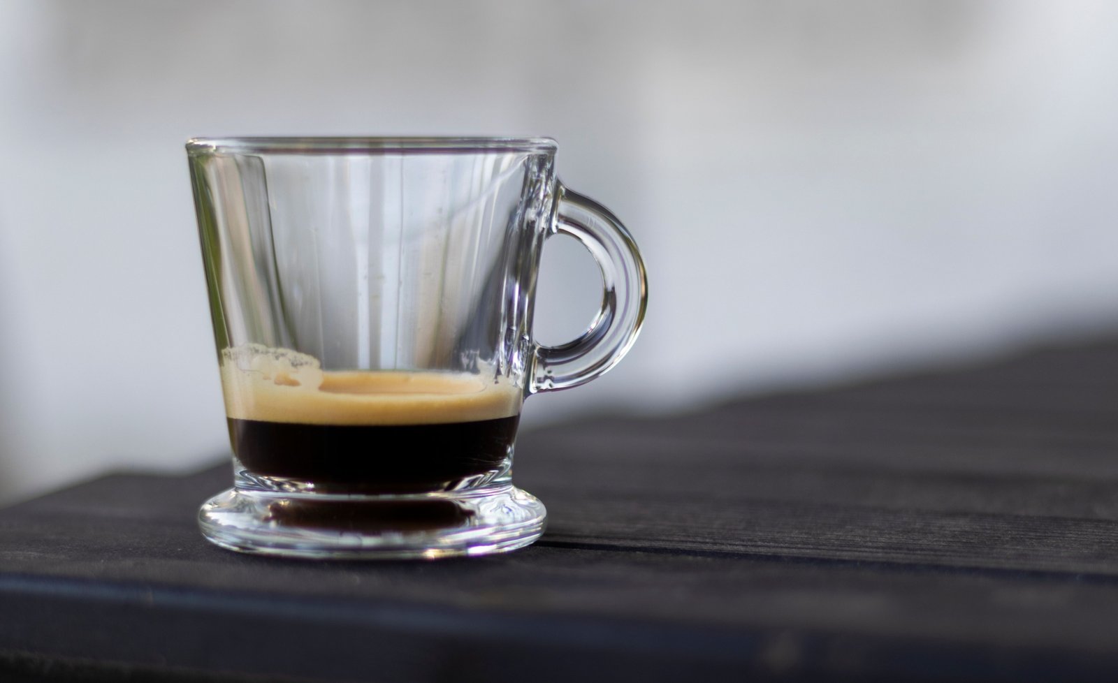Insulated espresso travel mug held outdoors by traveler enjoying fresh coffee on the go