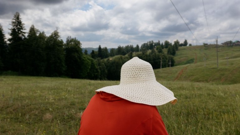 Woman wearing a wide brim travel sun hat for UV protection outdoors