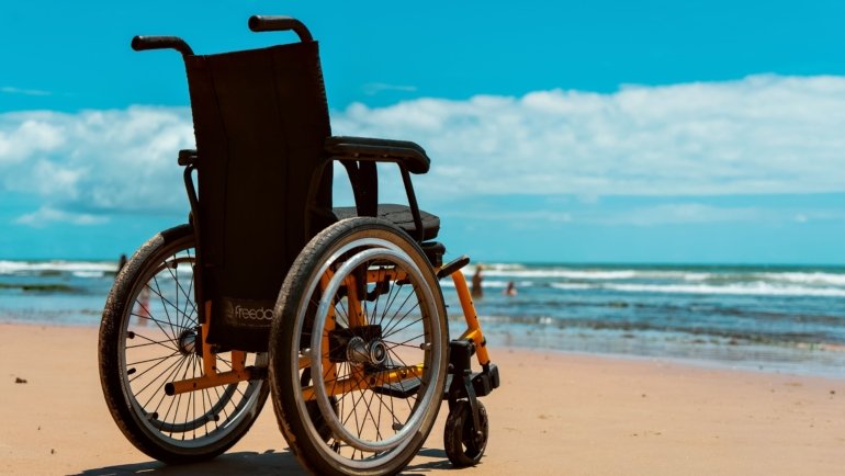 Traveler in wheelchair navigating an airport with accessible travel equipment and assistance for spinal cord injury