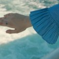 Close-up of a woman’s hand wearing a sparkling moissanite travel ring while exploring a new destination