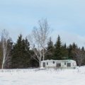 4 season off grid travel trailer in remote wilderness showcasing solar panels and durable design for year-round outdoor living