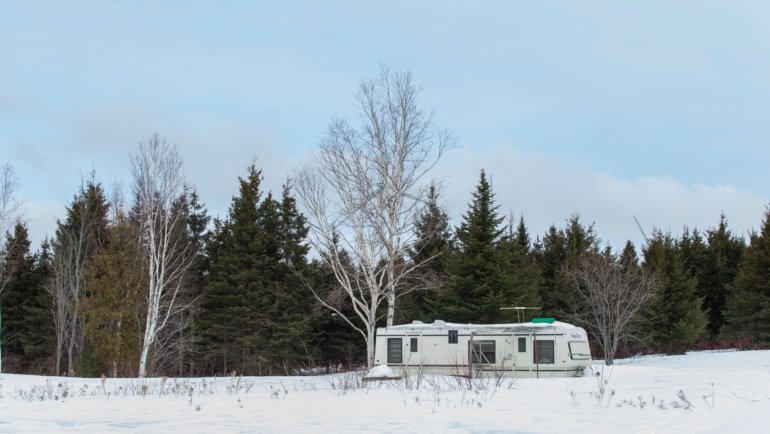 4 season off grid travel trailer in remote wilderness showcasing solar panels and durable design for year-round outdoor living