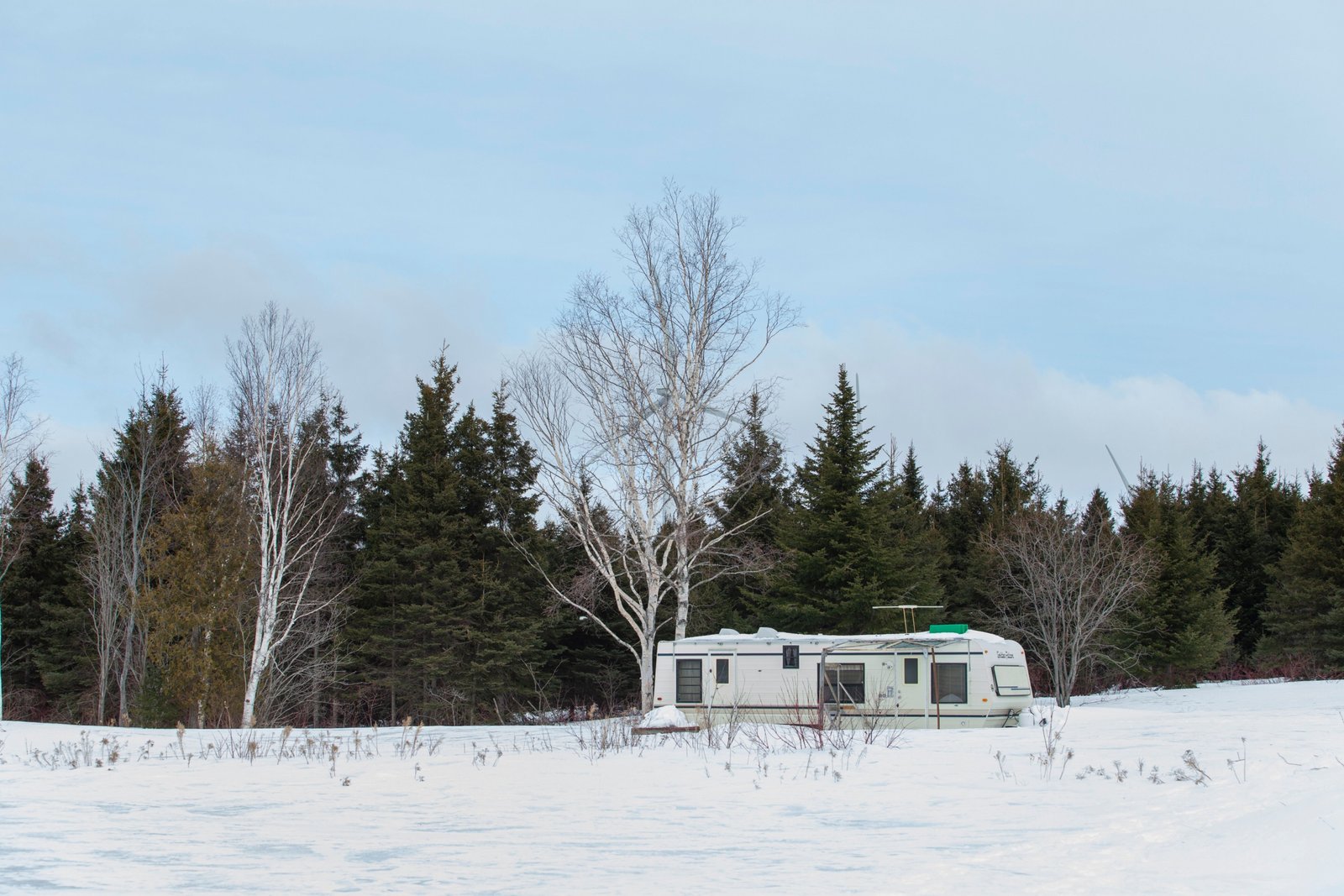 4 season off grid travel trailer in remote wilderness showcasing solar panels and durable design for year-round outdoor living