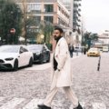Man wearing a stylish men's travel coat in a city street showcasing comfort, style, and weather protection