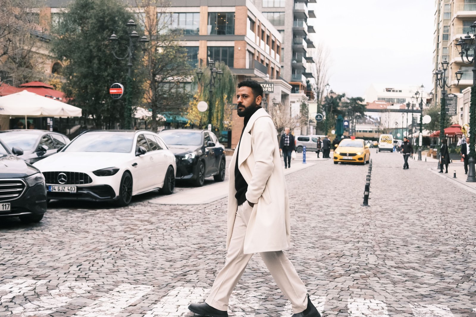 Man wearing a stylish men's travel coat in a city street showcasing comfort, style, and weather protection
