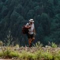 Man wearing lightweight breathable travel shorts hiking outdoors on a sunny day