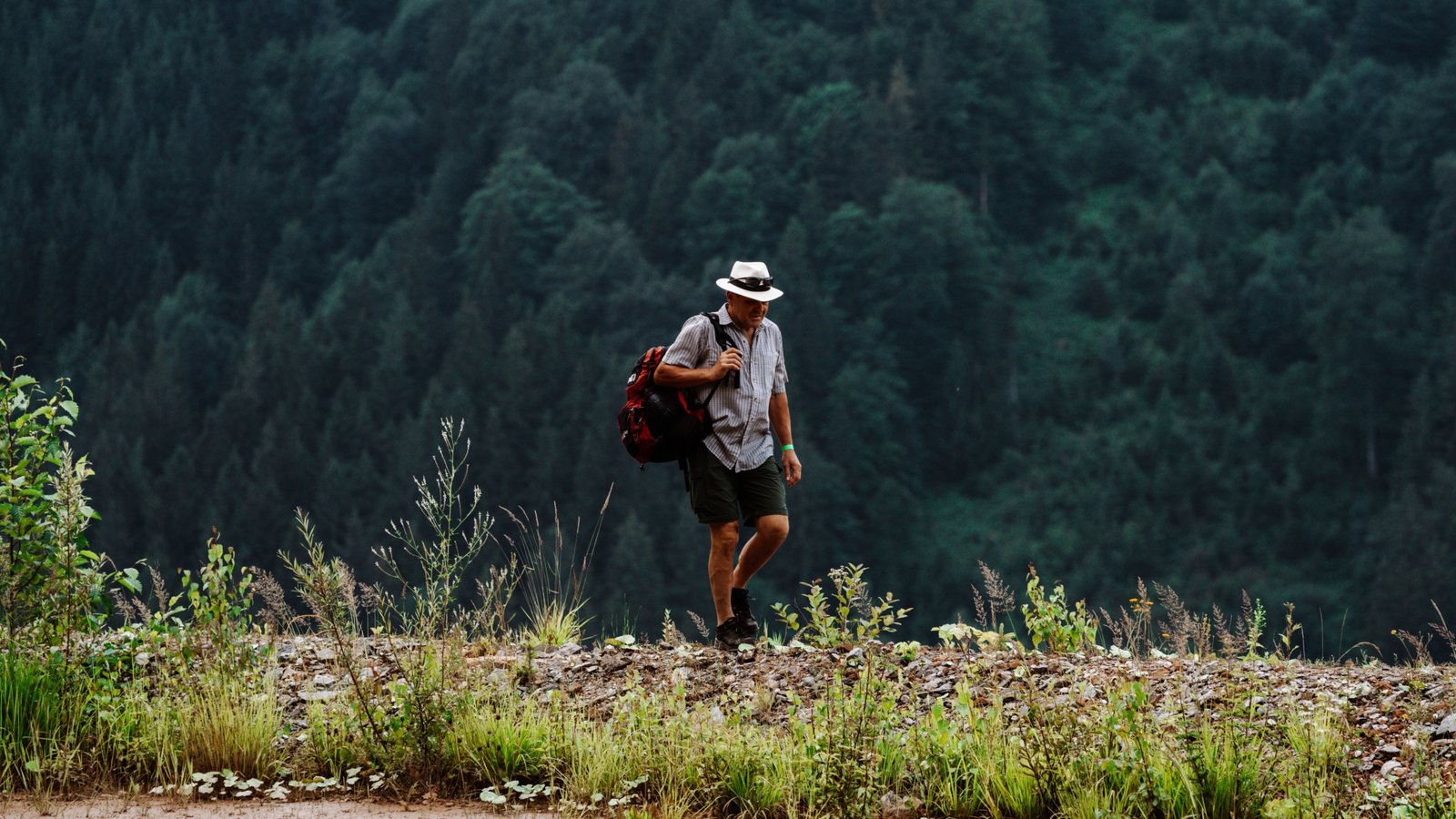 Man wearing lightweight breathable travel shorts hiking outdoors on a sunny day
