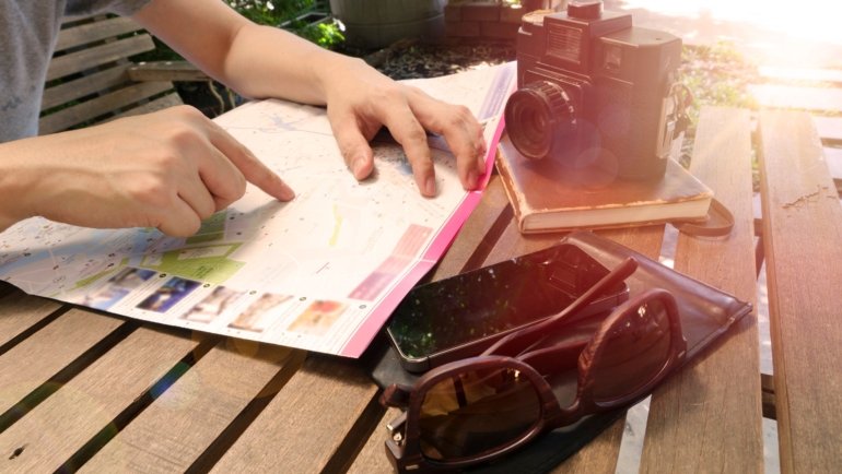 Close-up of Los Angeles travel guide book and map for trip planning with iconic cityscape background