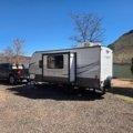 Jayco Jay Flight SLX travel trailer parked in nature, showcasing lightweight design and comfortable camping setup