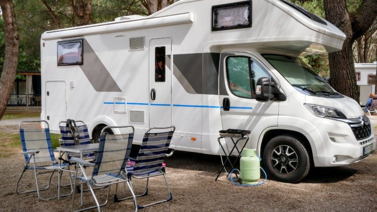 Used 2020 Winnebago Minnie 2500RL travel trailer parked in nature with family enjoying camping outdoors