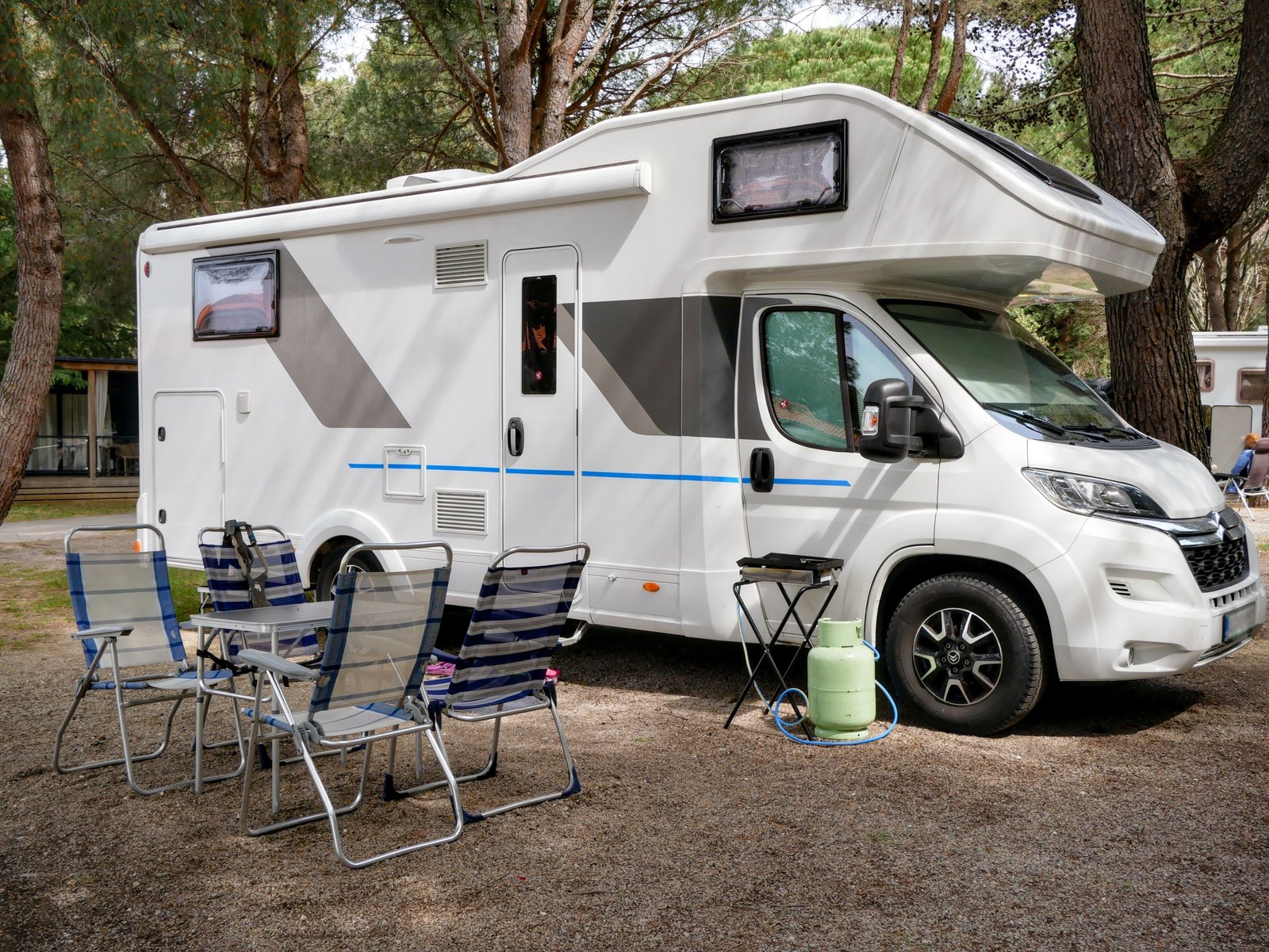 Used 2020 Winnebago Minnie 2500RL travel trailer parked in nature with family enjoying camping outdoors