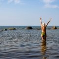 Happy naturist travelers enjoying a clothing-free beach experience with respect and freedom