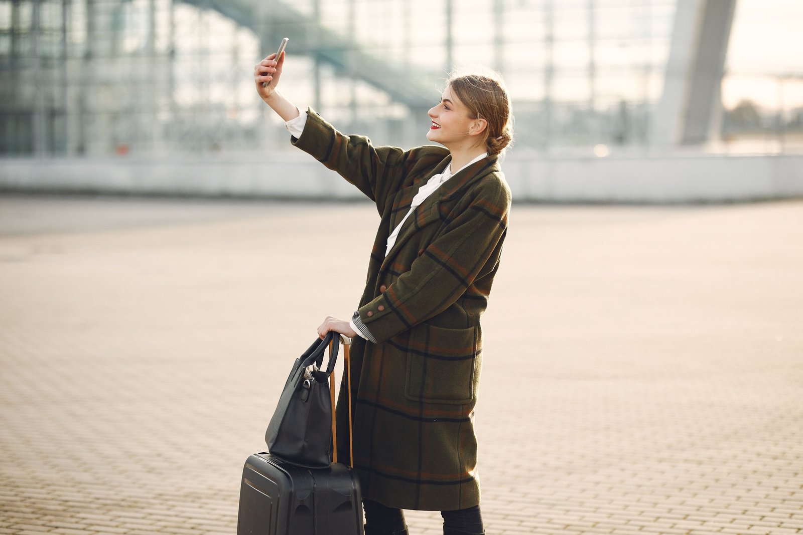 Traveler happily using smartphone to book a discounted trip with travel promo code