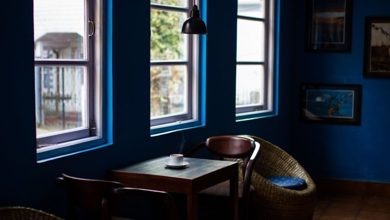 Traveler enjoying a cozy Scandinavian café with warm lighting and comfortable surroundings embracing hygge travel experience
