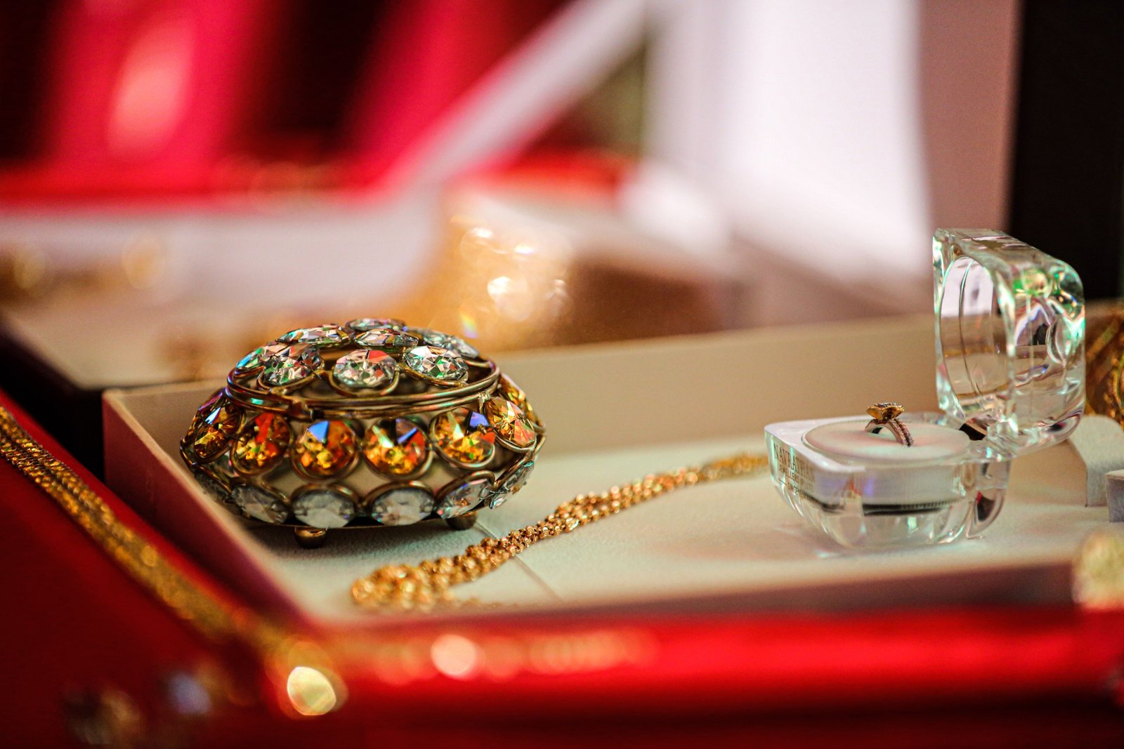 Luxury travel jewelry case open with compartments holding necklaces, rings, and bracelets on a soft velvet interior