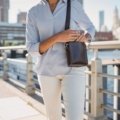 woman carrying a stylish secure travel purse in a city setting emphasizing travel convenience and safety