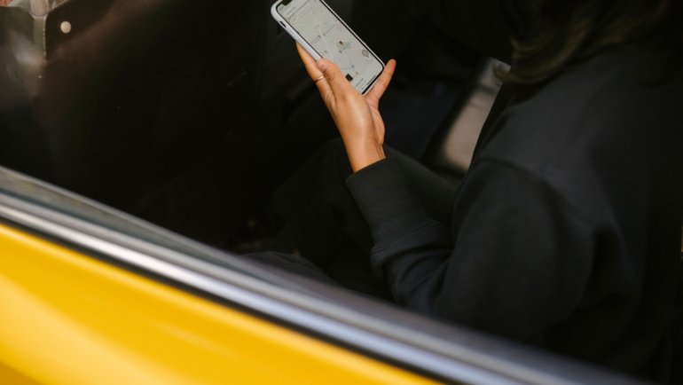 Traveler using smartphone with travel applications for navigation and booking during trip planning