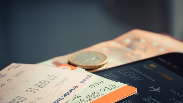 Traveler organizing and prioritizing flights, hotels, and car rentals on smartphone for seamless trip planning