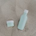 Kevin Murphy Angel Wash travel size shampoo bottle in toiletry bag with beach background for hair care on the go