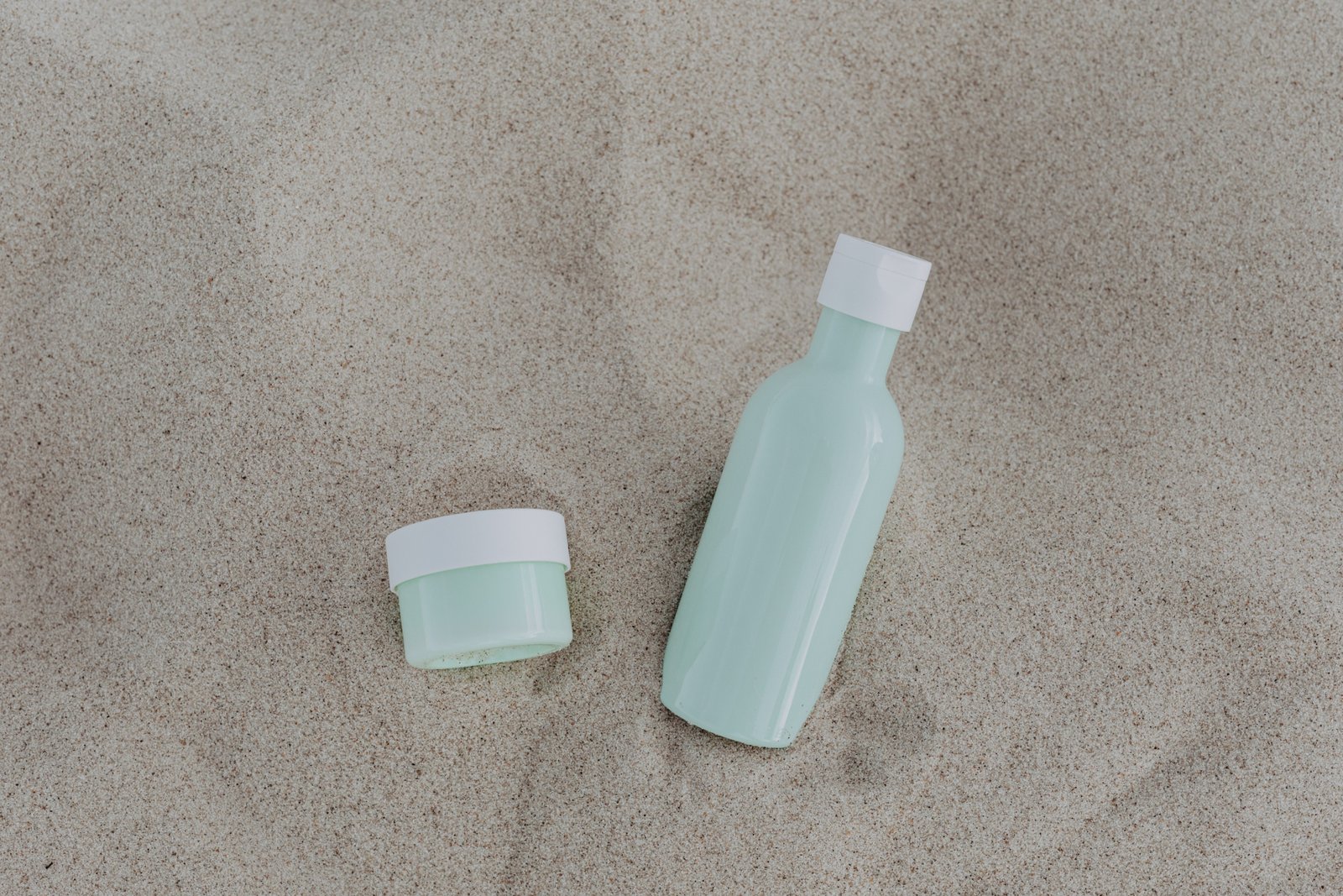 Kevin Murphy Angel Wash travel size shampoo bottle in toiletry bag with beach background for hair care on the go