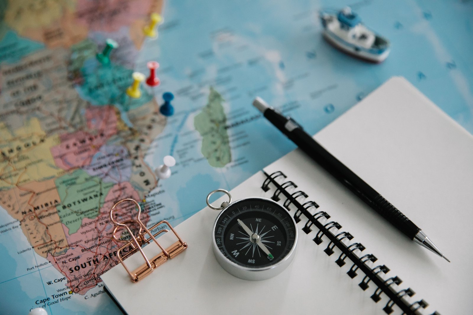 Traveler planning Peru trip with a travel guidebook, maps, and notes on a wooden table