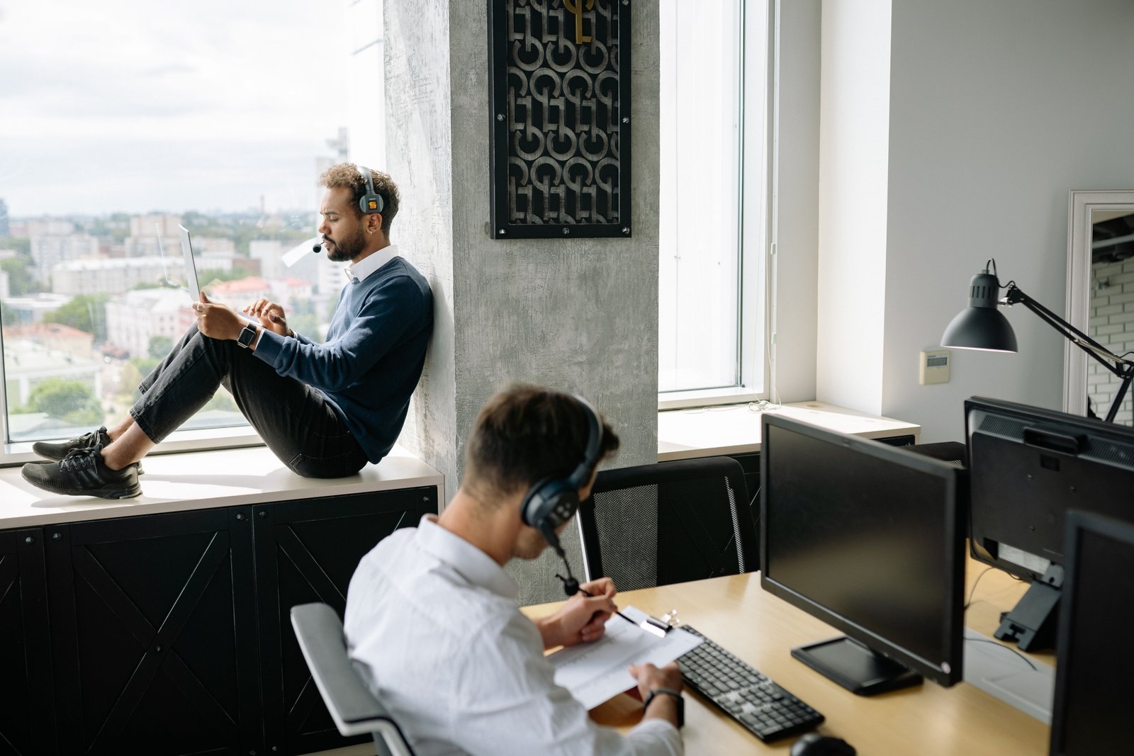 Travel agent helping client plan a customized trip using a laptop in a modern office