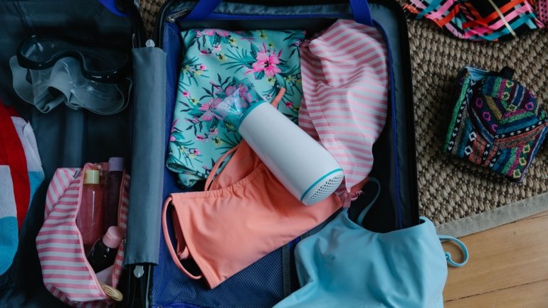 Compact travel pump bottle being packed into luggage for organized and hygienic travel