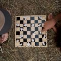 portable magnetic travel chess set in outdoor setting with person playing chess