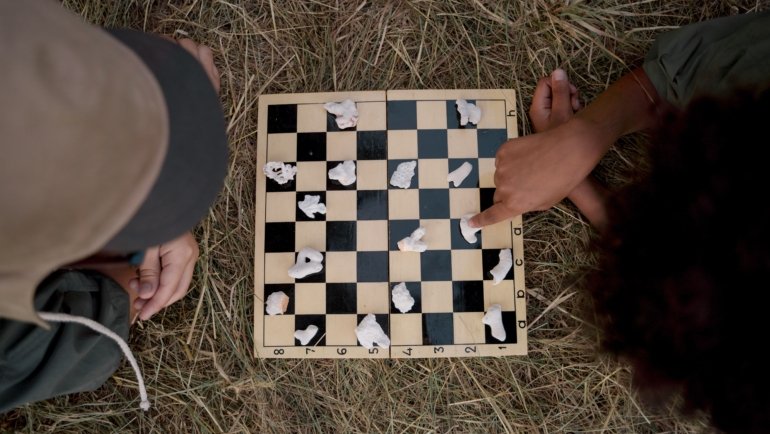 portable magnetic travel chess set in outdoor setting with person playing chess