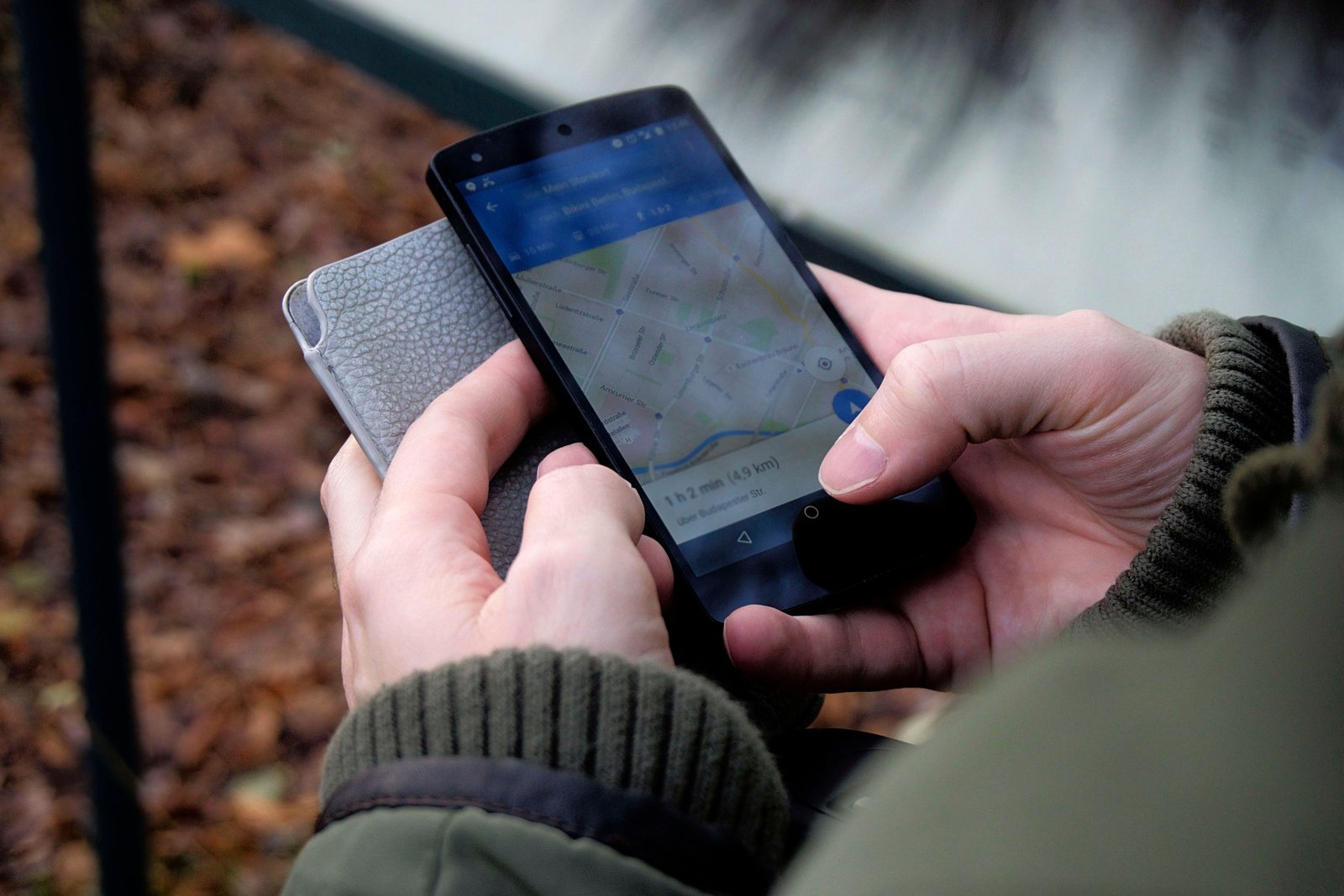 Traveler checking smartphone data usage outdoors to manage mobile internet while navigating and communicating during trip
