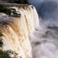 Stunning Iguazu Falls waterfall surrounded by green rainforest under clear sky