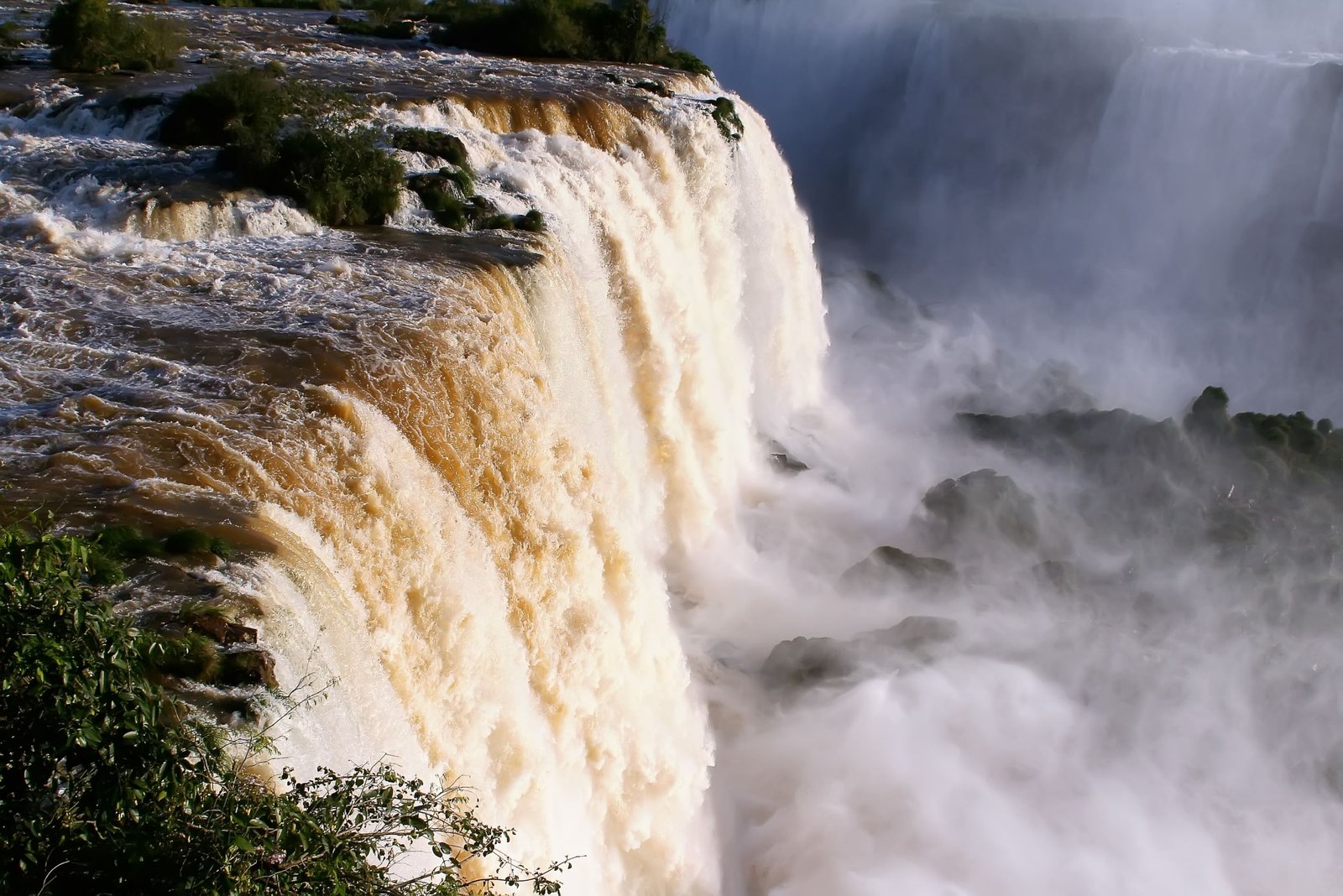 Stunning Iguazu Falls waterfall surrounded by green rainforest under clear sky