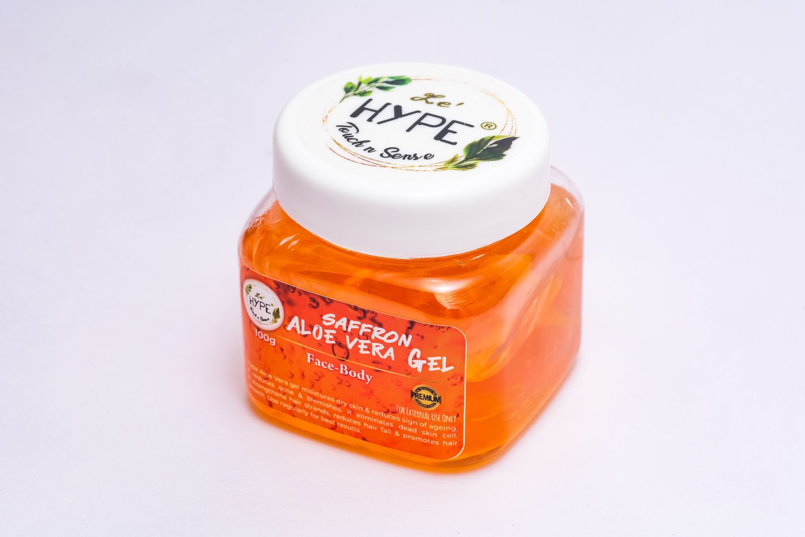 Travel size aloe vera gel bottle next to backpack and sunglasses for soothing and moisturizing skin care on the go