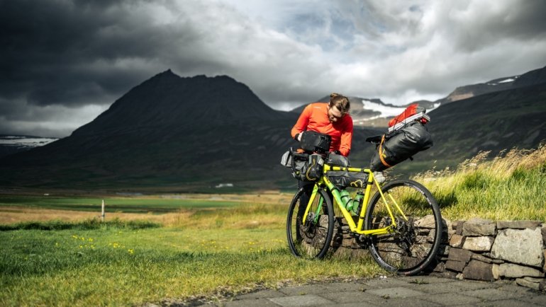 Cyclist packing bike into a protective EVOC travel case ready for secure transportation