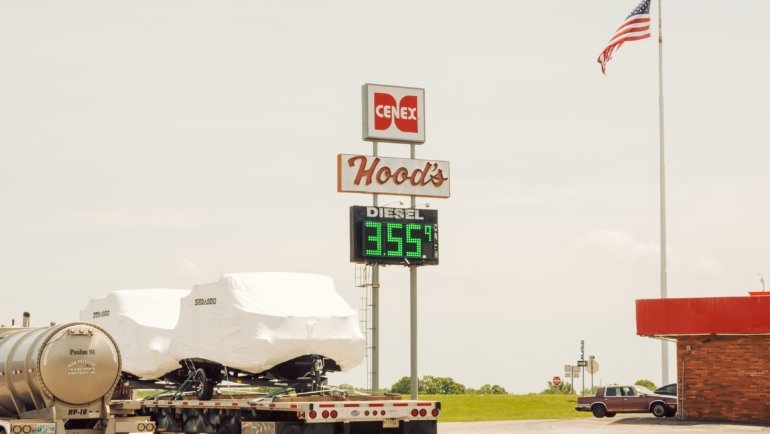 Busy truck stop fuel station with large trucks refueling and convenience store near highway