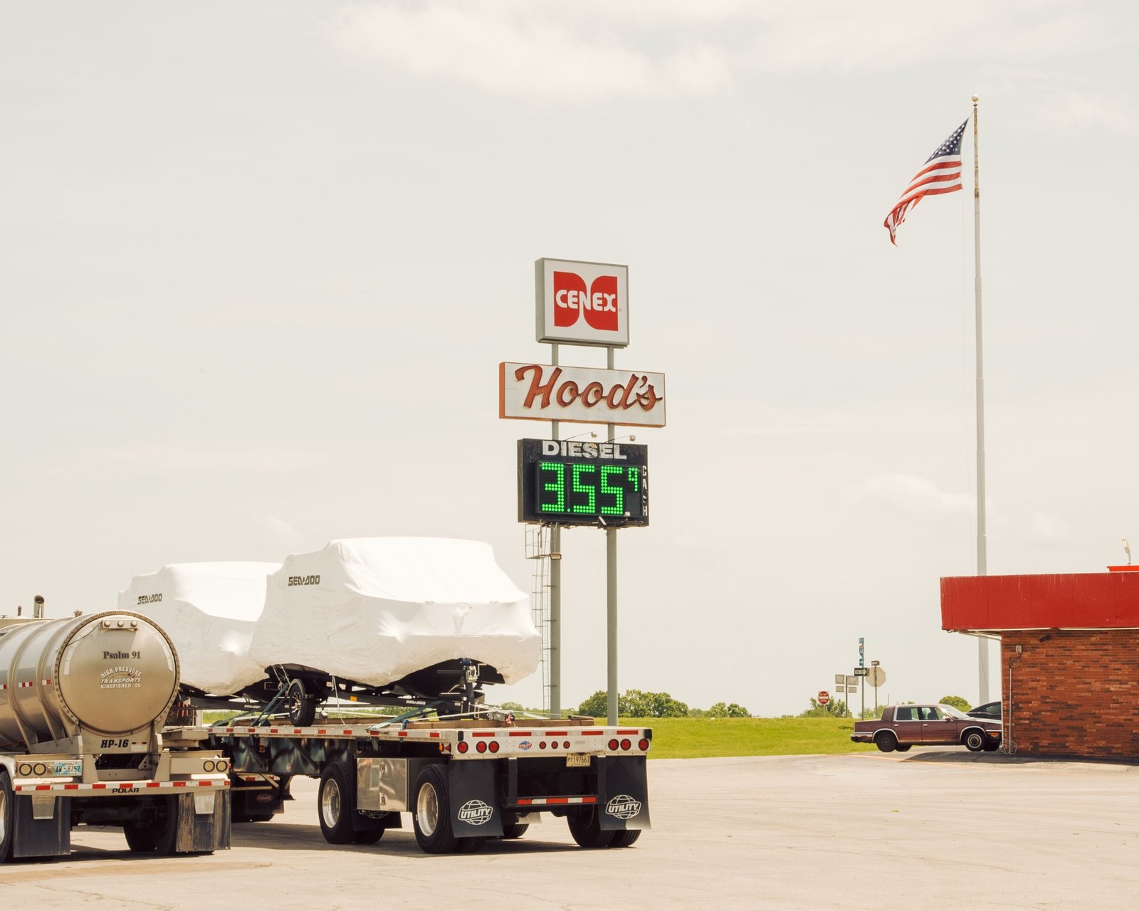 Busy truck stop fuel station with large trucks refueling and convenience store near highway