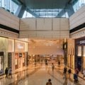 Affluent Asian travelers shopping at a luxury duty-free store with digital displays and exclusive products
