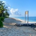 Sunny tropical beach in Honduras with clear skies and turquoise waters during the dry season