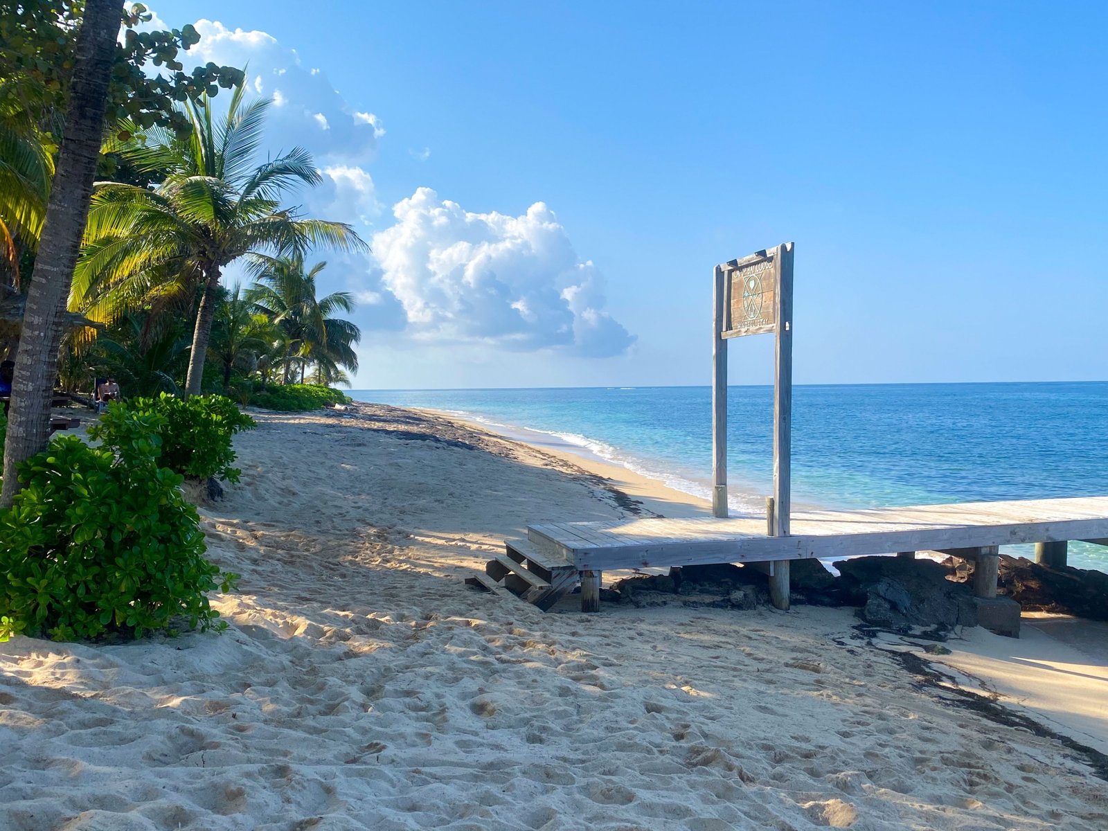 Sunny tropical beach in Honduras with clear skies and turquoise waters during the dry season