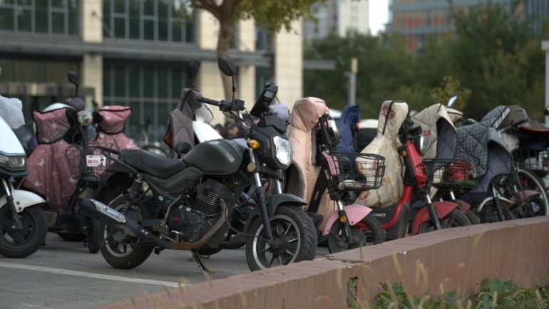 Electric bike covered with waterproof travel cover protecting against weather and damage