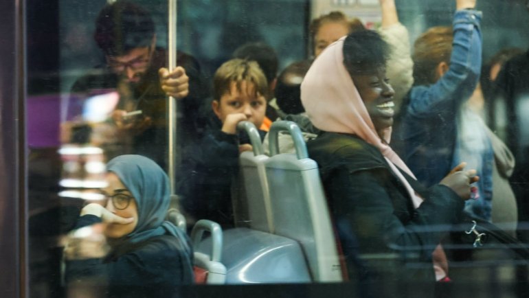 Diverse group of happy passengers enjoying free bus travel in a city bus