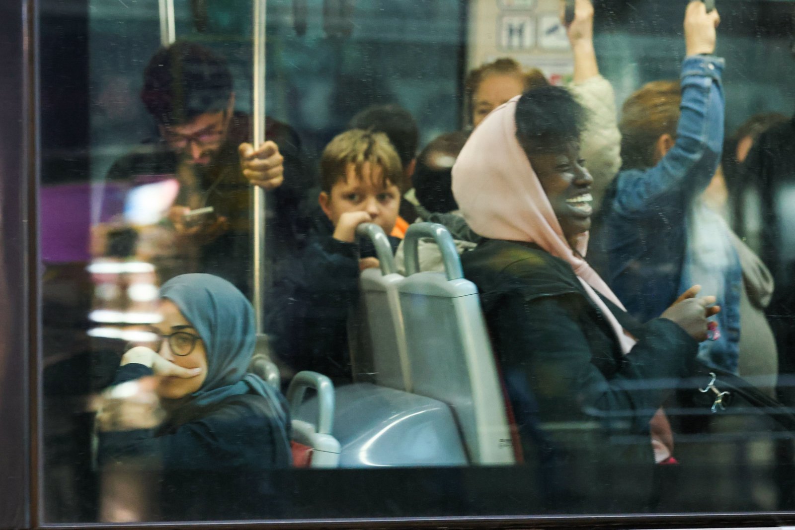 Diverse group of happy passengers enjoying free bus travel in a city bus