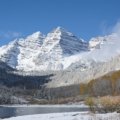 Scenic Aspen mountain landscape with snowy peaks and lush green trails representing winter and summer activities