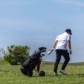 Golfer carrying golf bag at airport representing golf travel insurance and equipment protection