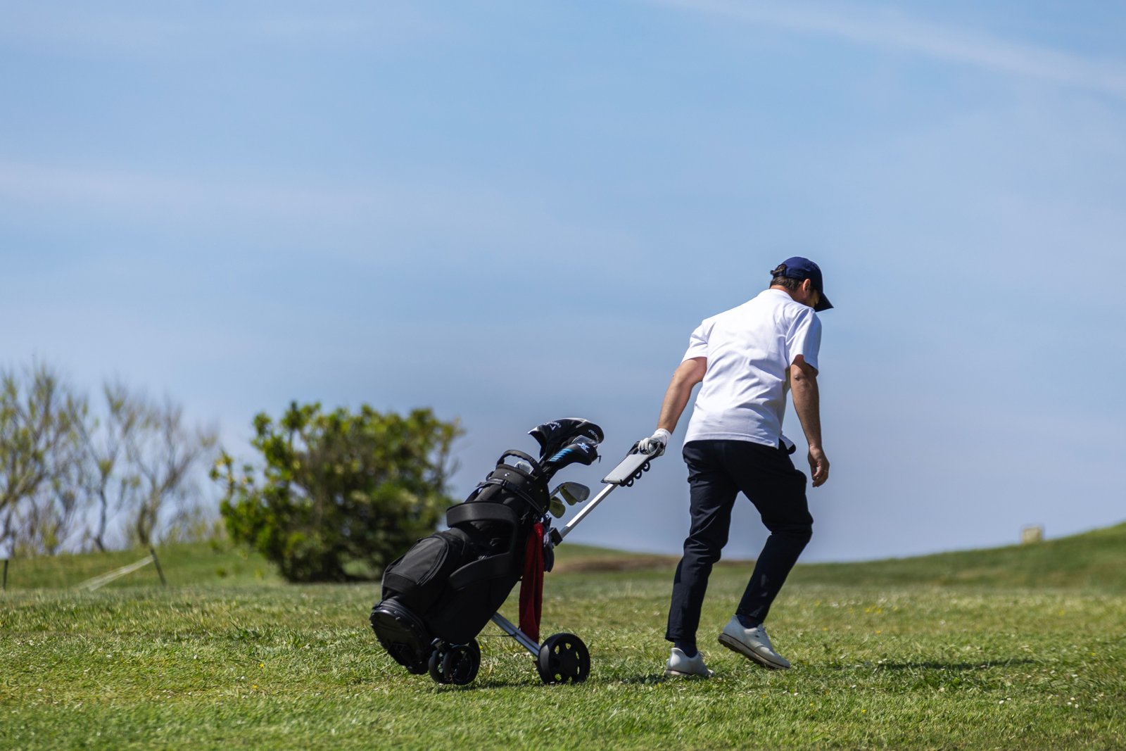 Golfer carrying golf bag at airport representing golf travel insurance and equipment protection