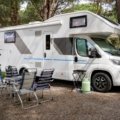 Alpha Wolf travel trailer parked in a natural outdoor setting, highlighting its modern design, spacious interior, and rugged durability for adventurous travelers
