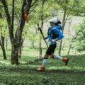 Ultramarathon runner on rugged forest trail during Arkansas Traveller 100 race at sunrise