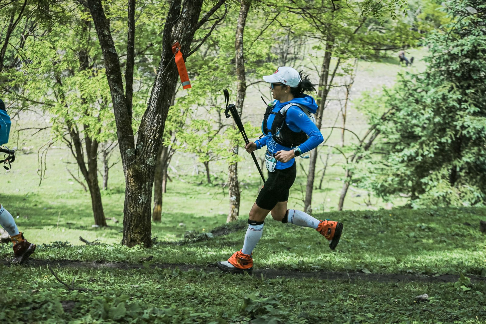 Ultramarathon runner on rugged forest trail during Arkansas Traveller 100 race at sunrise